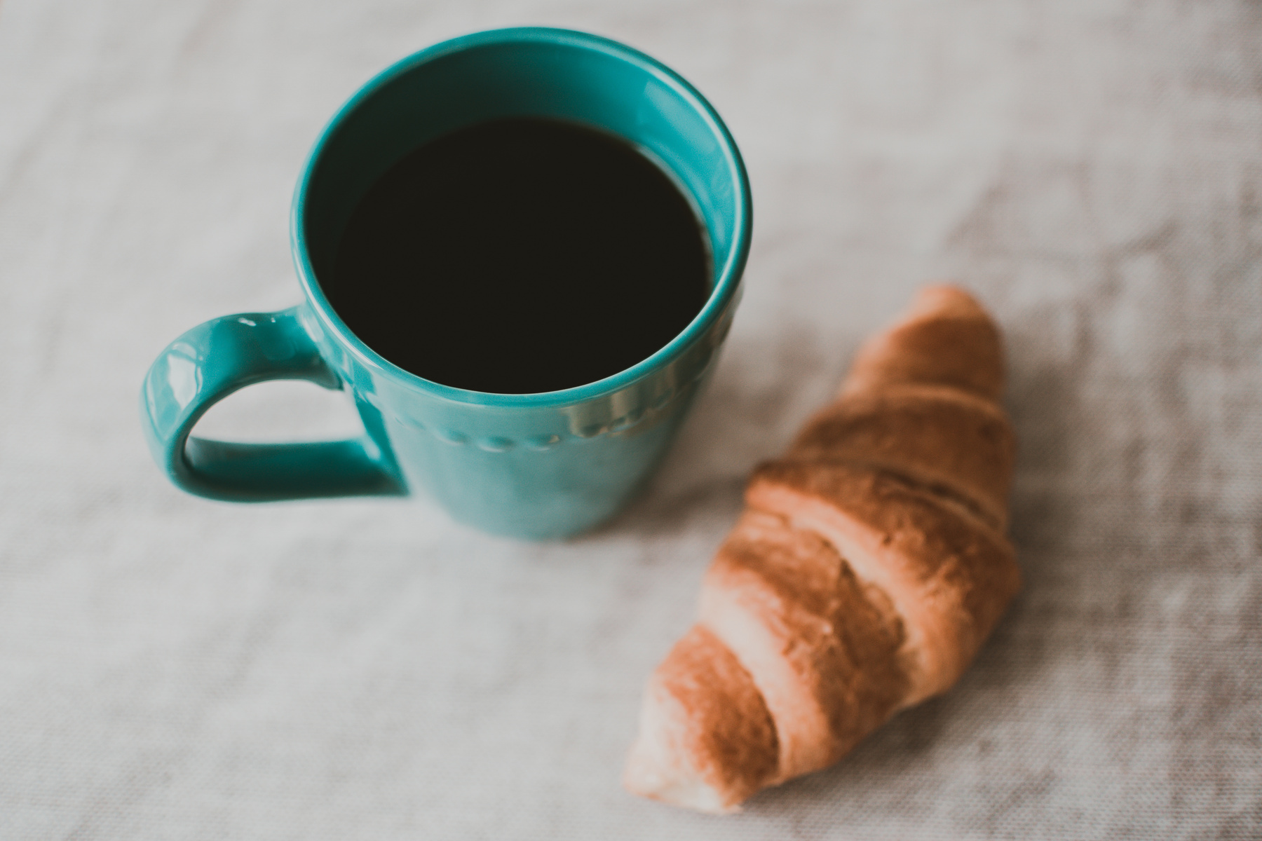 Teal Ceramic Mug Filled With Coffee Near Baked Bread